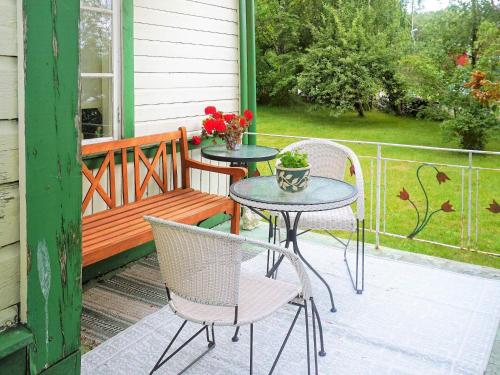 eine Terrasse mit 2 Stühlen, einem Tisch und einer Bank in der Unterkunft 5 person holiday home in TINGSRYD in Tingsryd