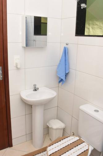 La salle de bains est pourvue d'un lavabo, de toilettes et d'un miroir. dans l'établissement Carvalho de Paquetá, à Rio de Janeiro