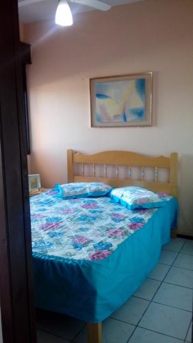 um quarto com uma cama com uma colcha em LINDO AP CAPAO NOVO em Capão da Canoa