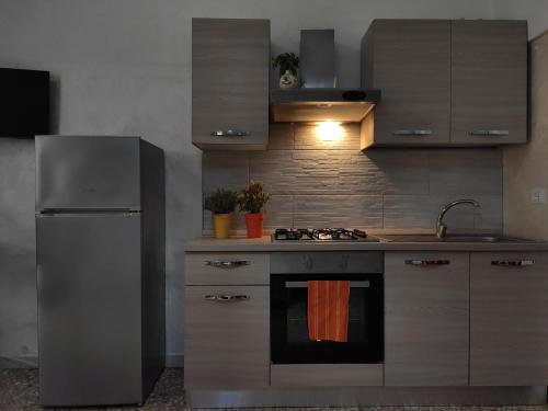una cucina con piano cottura e frigorifero di House Serena a Galatone