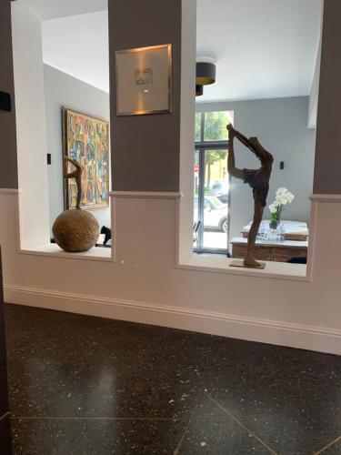 two mirrors on a wall with sculptures in a room at Das Nikolai Hotel in Munich