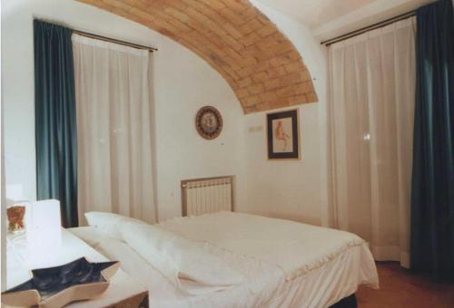 a bedroom with a white bed and a table and window at Villino Corbelli B&B in Rome