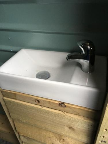 a white sink with a faucet on top of it at Belan Bluebell Woods Shepherds Hut in Llanidloes