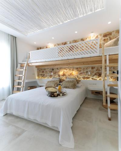 a bedroom with a large white bed and bunk beds at Manda Luxury Apartments in Naxos Chora