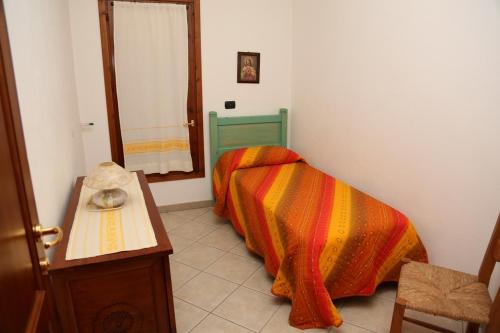 a bedroom with a bed with a colorful blanket at luna e sole in Orosei