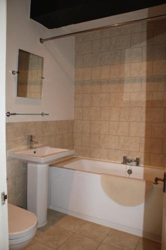 a bathroom with a tub and a sink and a toilet at The Coach House in Bristol