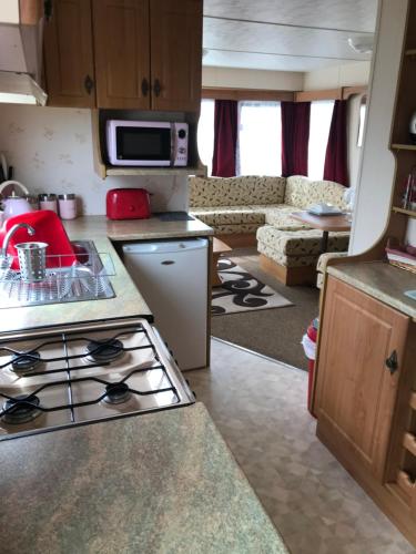 a kitchen with a stove top oven in a caravan at Caravan to Hire Dymchurch in Dymchurch