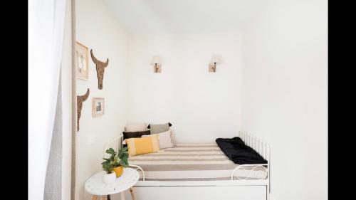 a small bedroom with a bed in a white wall at Casa Yandiola in Castro-Urdiales