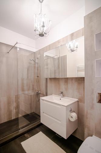 a bathroom with a sink and a shower and a toilet at BLISS Apartment in Constanţa