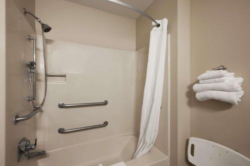 a bathroom with a shower and a toilet and towels at Super 8 by Wyndham Cromwell/Middletown in Cromwell