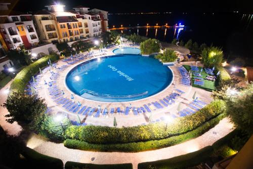 an overhead view of a large swimming pool at night at Marina Cape Vacation Complex in Ravda