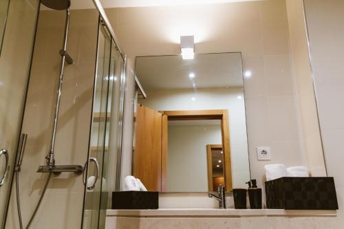 y baño con ducha y espejo. en PRIME PARQUE RESIDENCE, en São Martinho do Porto