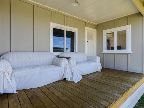 a living room with two white couches and a table at Harper Haven - Waimarama Holiday Home in Waimarama