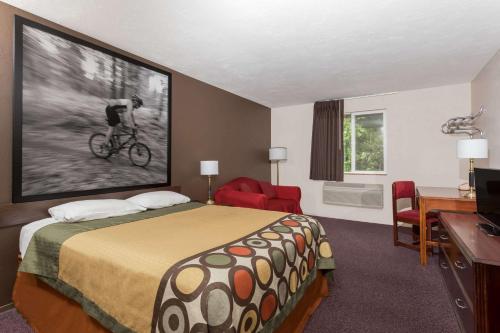 a hotel room with a bed and a bike on the wall at Super 8 by Wyndham Shelton in Shelton