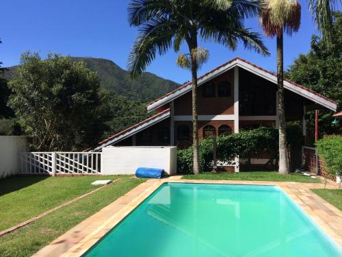ein Haus mit einem Pool vor einem Haus in der Unterkunft O Silêncio que Canta in Águas de Lindóia