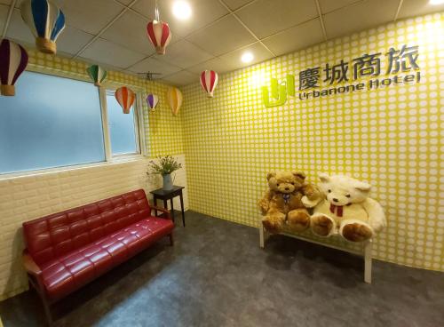 two teddy bears sitting on a bench in a waiting room at Urbanone Hotel in Taipei