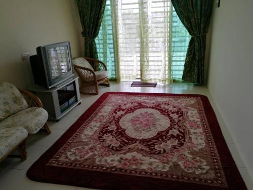 a living room with a red rug on the floor at Alma Homestay 