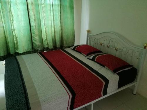 two twin beds in a bedroom with green curtains at Alma Homestay 