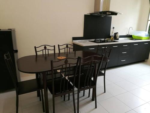 a kitchen with a table and chairs in a room at Alma Homestay in Kampong Masjid