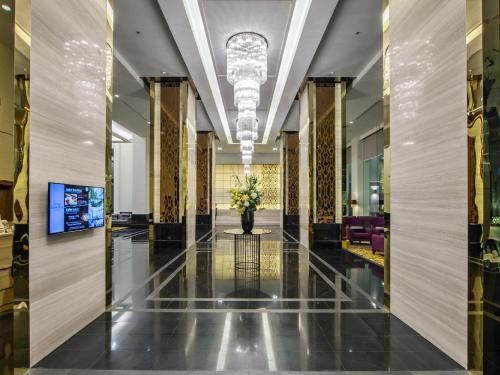 a lobby of a building with a vase of flowers at Grande Centre Point Ploenchit in Bangkok
