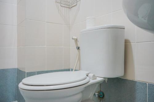 a bathroom with a white toilet with a roll of toilet paper at New Furnished with City View 1BR at Akasa Pure Living BSD Apartment By Travelio in Ciater-hilir