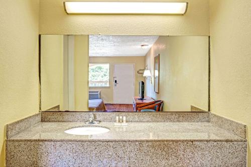 baño con lavabo y espejo grande en Days Inn by Wyndham Chesapeake en Chesapeake