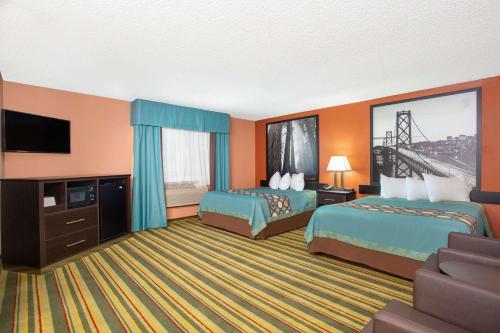 a hotel room with two beds and a television at Super 8 by Wyndham Chico in Chico
