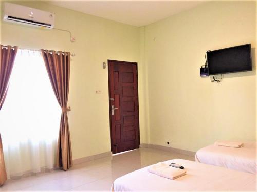 En eller flere senge i et værelse på Hotel The Village Syariah