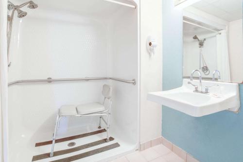 een witte badkamer met een wastafel en een douche bij Super 8 by Wyndham Springfield-Battlefield in Springfield