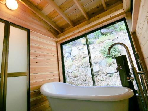 uma grande banheira numa casa de banho com uma janela em Shirahama Meiji Villa em Shirahama