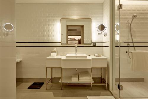 a bathroom with a sink and a mirror at Montien Hotel Surawong Bangkok in Bangkok