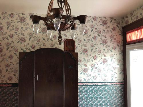 a chandelier and a cabinet in a room with wallpaper at Near the pier in Astoria, Oregon
