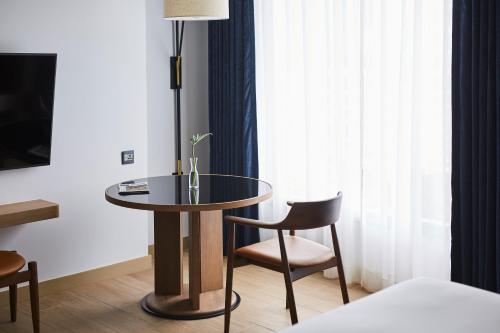 a table and a chair in a room at Montien Hotel Surawong Bangkok in Bangkok