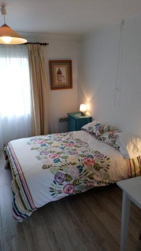 a bedroom with a bed with a floral bedspread at Kermaner in Tréveneuc