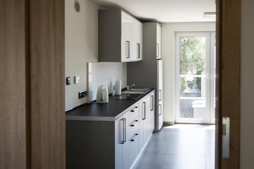 a kitchen with white cabinets and a black counter top at Rudzka 77 in Racibórz
