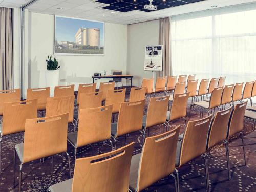 a room with rows of chairs in a classroom at Mercure Compiègne Sud in Compiègne