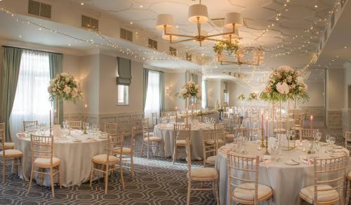 a banquet hall with tables and chairs in a room at Wotton House in Dorking