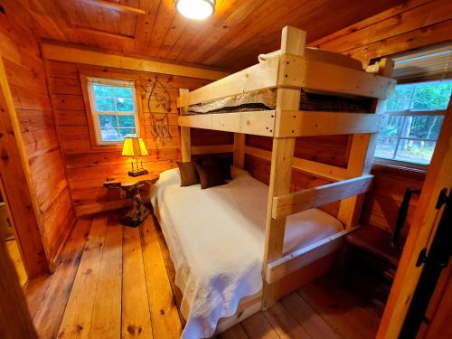 ein Schlafzimmer mit einem Etagenbett in einem Blockhaus in der Unterkunft Lil' Log at Hearthstone Cabins and Camping - Pet Friendly in Helen