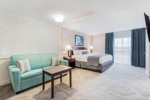 a hotel room with a bed and a couch and a table at The Blu Hotel Blue Ash Cincinnati, Ascend Hotel Collection in Blue Ash
