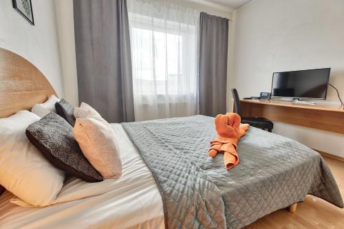 a bedroom with a bed with a stuffed animal on it at Luxury Suites - Tatari by Rikas Hotels in Tallinn