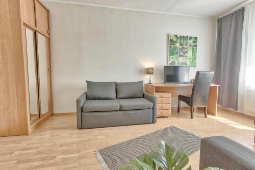 a living room with a couch and a chair and a desk at Luxury Suites - Tatari by Rikas Hotels in Tallinn