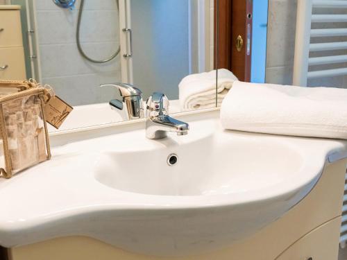 een badkamer met een witte wastafel en een spiegel bij Terrazza del Gelsomino with terrace and open view in Borghetto Santo Spirito