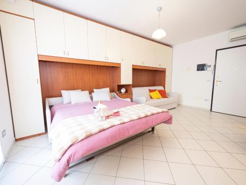een grote slaapkamer met een groot bed en een bank bij Terrazza del Gelsomino with terrace and open view in Borghetto Santo Spirito