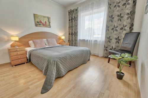 a bedroom with a bed and a chair and a window at Luxury Suites - Tatari by Rikas Hotels in Tallinn