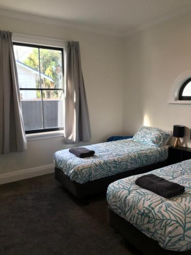 布倫海姆的住宿－Te Waiharakeke Holiday Home，客房设有两张床和窗户。