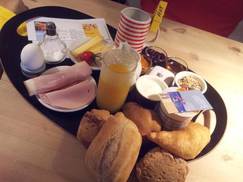 a plate of food with bread and eggs and a drink at Blue Wall BnB in Gebenstorf