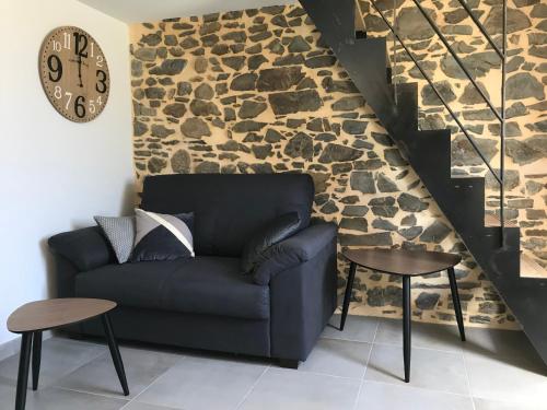 sala de estar con sofá y pared de piedra en Ti Bihan en Pordic