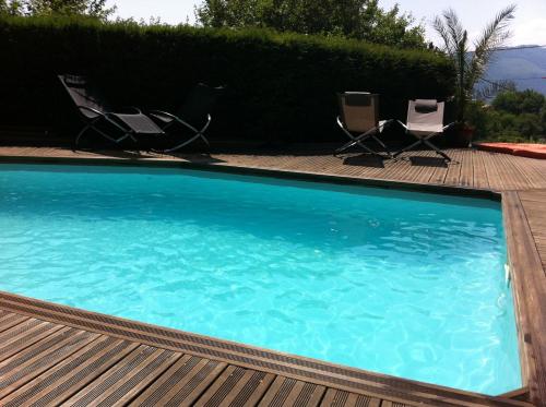 a swimming pool with two chairs and a deck at Loft "Home, Sauna & Pool" in Osenbach