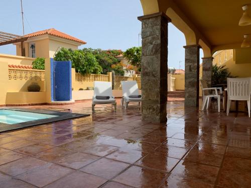 um pátio com cadeiras e uma piscina numa casa em Casa Vista del Mar 1 em Morro del Jable