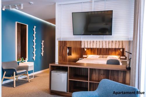 a bedroom with a bed and a television on a wall at Pokoje4you in Koszalin